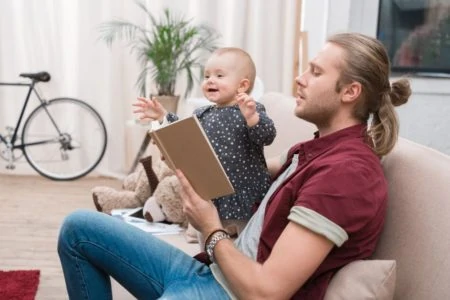 Father reading to baby on the sofa