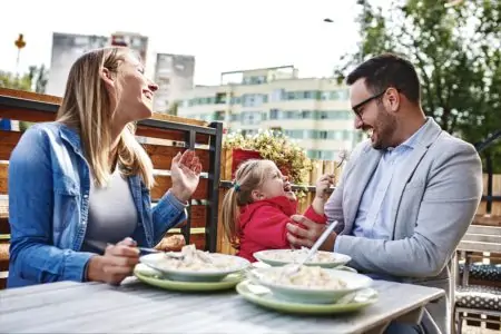 Happy family enjoying pasta in restaurant.