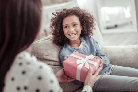 Beautiful African girl receiving a gift with a smile