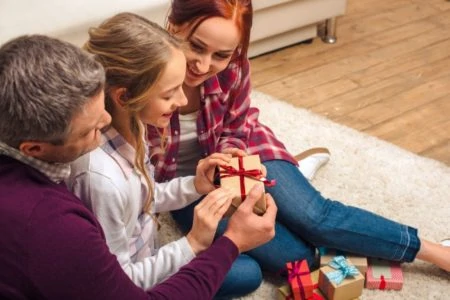 Mother and father giving presents to preteen daughter