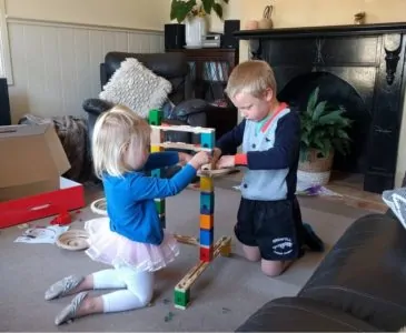 Little boy and girl playing with a marble run toy