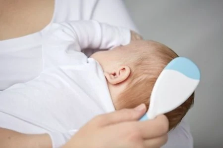 Mother brushing her baby's hair