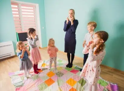 Children learning body parts with teacher in kindergarten