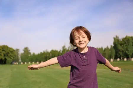 Cute little boy relaxing in park on sunny day