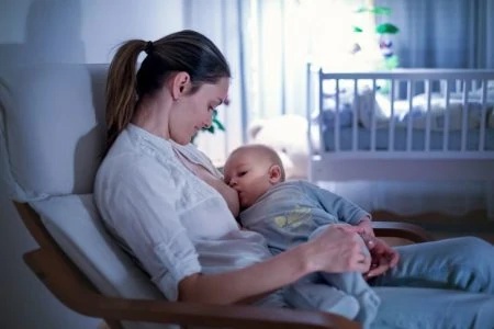 Mother breastfeeding her baby at night