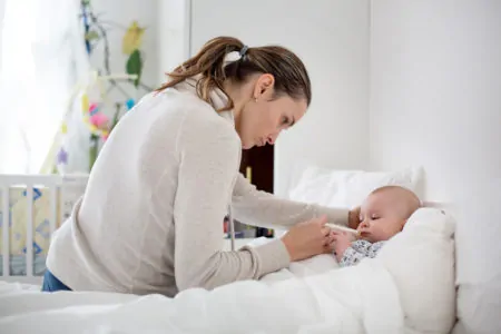 Mom giving pedialyte to sick baby