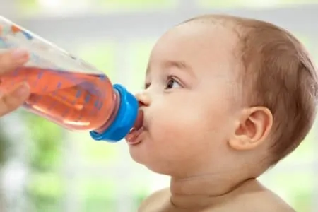 Baby drinking tea from bottle