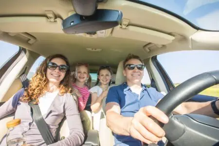 Parents and their children sitting in the car.