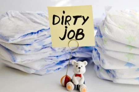 Stack of disposable diapers with a sign that reads 