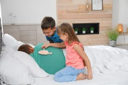 Children sticking paper fish to their father's back