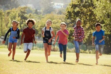 Kids running in the park playing red light green light game