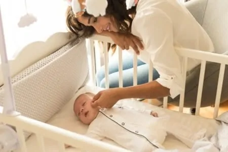 Mother putting baby to sleep