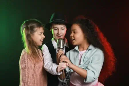 Little children singing in microphone on stage