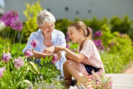 Kind young girl helping her grandmother in gardening