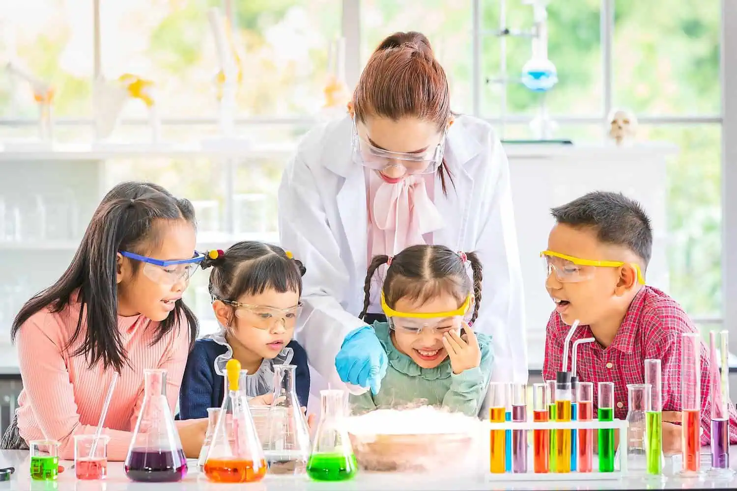 Kids doing experiment with their teacher at science laboratory