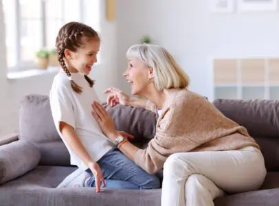 Grandmother playing with granddaughter on couch