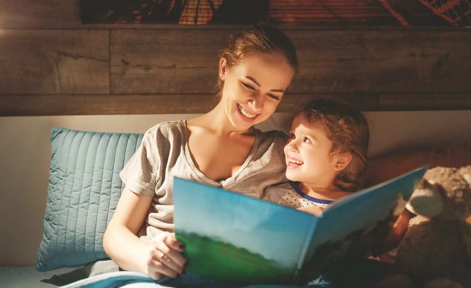 Mother and daughter reading book in bed