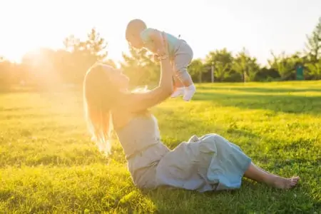 Mother lifting baby boy to the sky