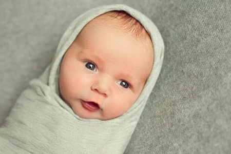 Baby being swaddled in summer