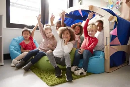 Preschool kids raising their hands to answer questions