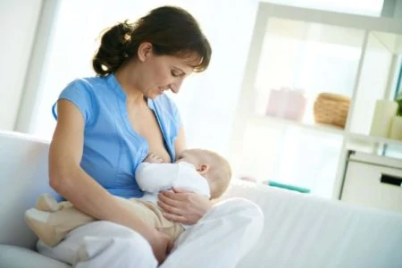 Mother breastfeeding on the sofa