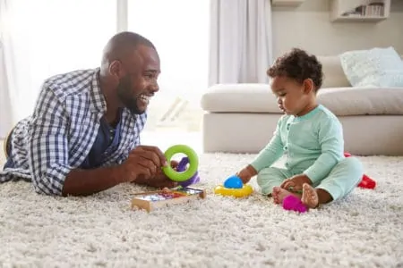 Baby sitting up while playing with dad