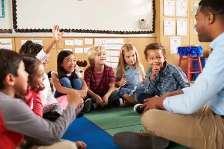 Young kids happily asking questions in a group