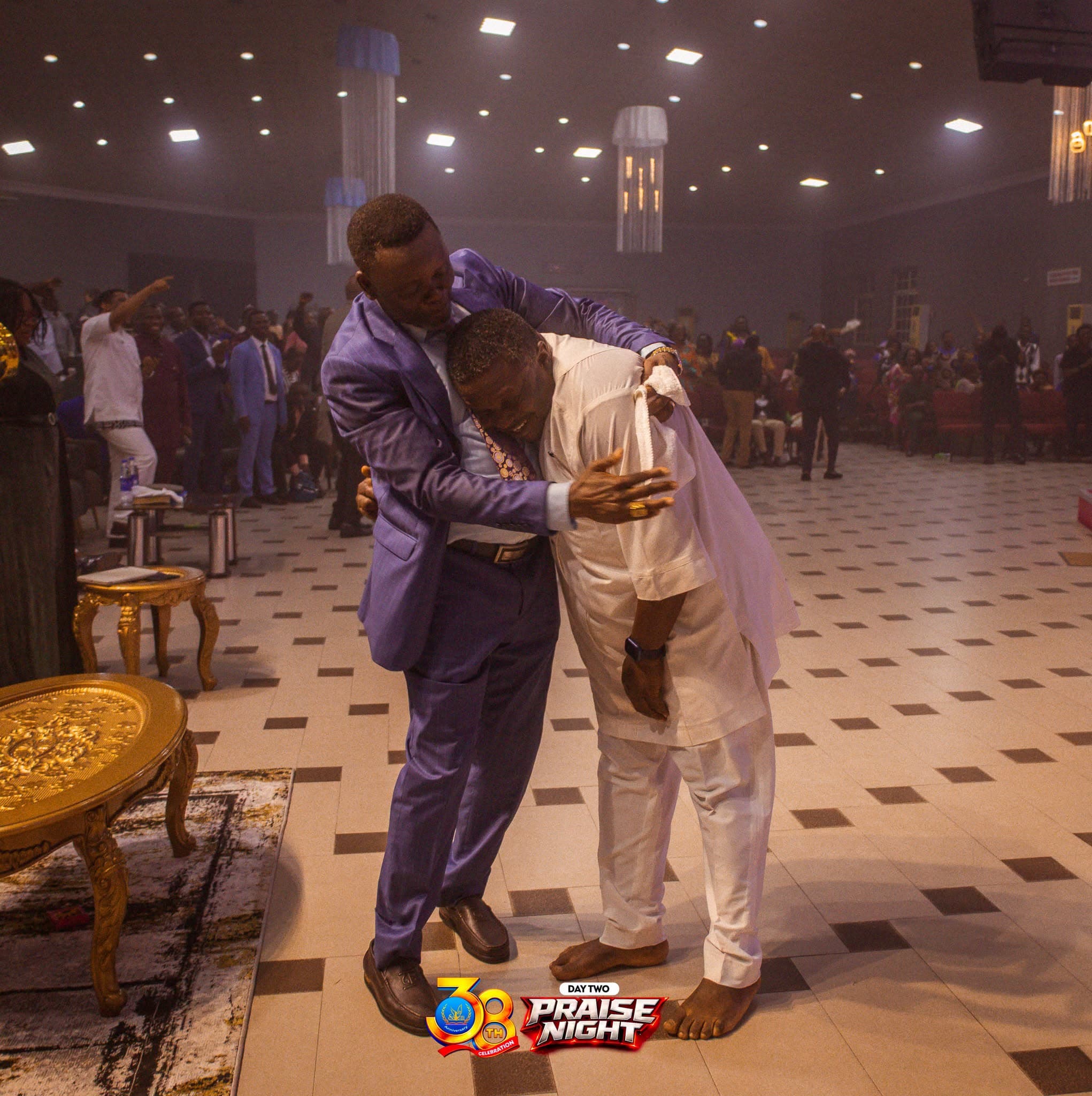 Two members sharing a warm embrace during a praise night service