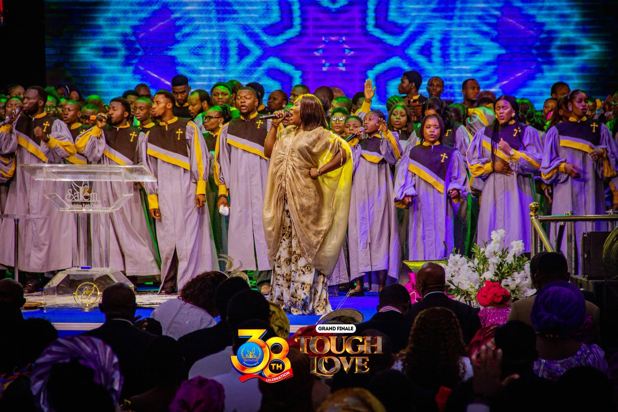 The choir in robes leading the congregation in worship, with a soloist singing at the front